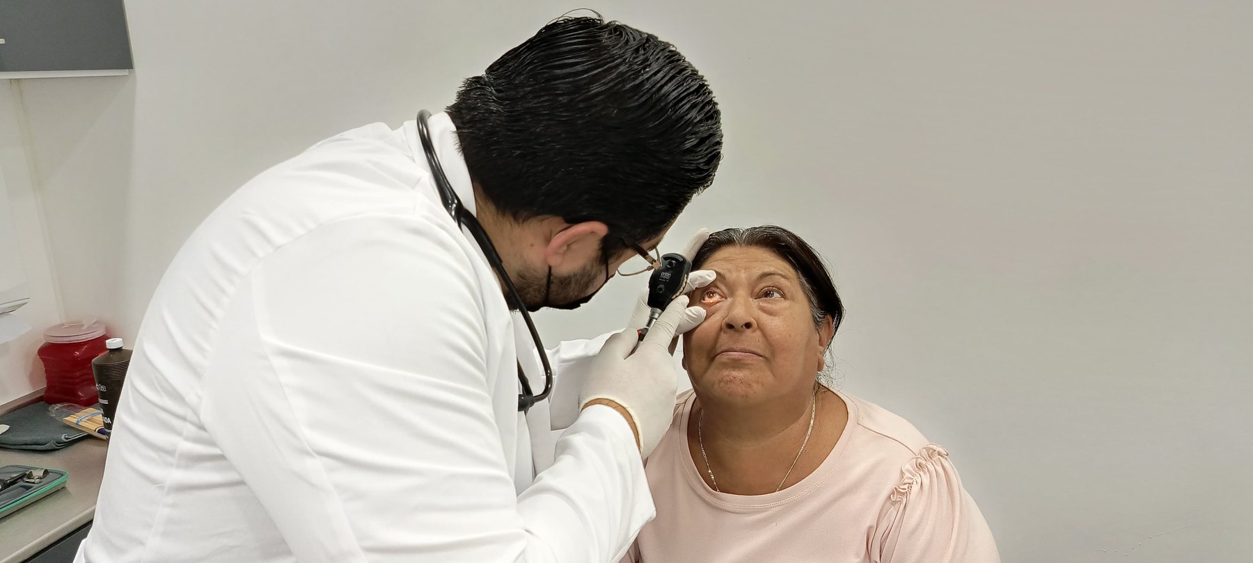 Médico revisando el ojo de una paciente como parte de salud e inversión social